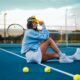 woman in blue dress sitting on tennis court