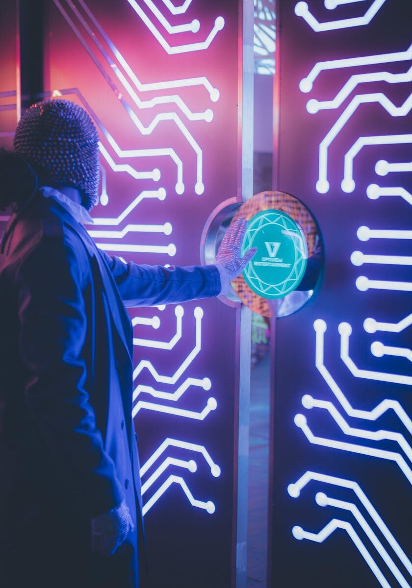 A person interacts with a neon-illuminated futuristic tech panel in a dark room.