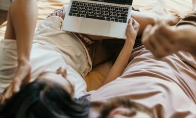 Couple relaxing in bed watching Netflix on a laptop, capturing a cozy moment indoors.