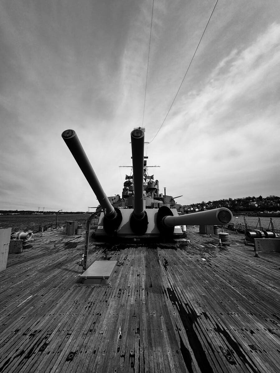 Dramatic black and white photo of USS Alabama battleship showcasing its powerful cannons.