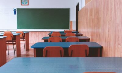 A tranquil empty classroom with wooden furniture and a green chalkboard, perfect for educational themes.