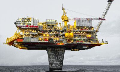 A well-lit offshore oil platform against a cloudy sky in Norway's waters.