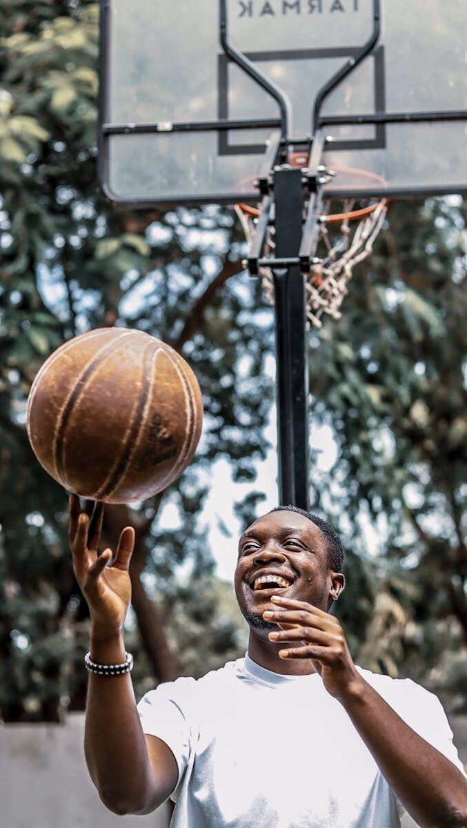 A young man enjoying playing basketball on a sunny day in Accra, Ghana.