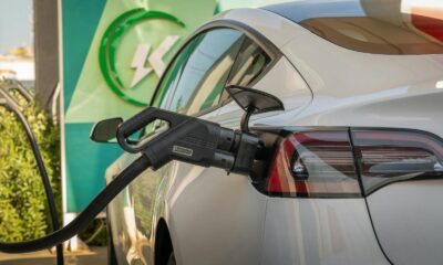Close-up of Tesla Model 3 connected to a charging station, highlighting eco-friendly transportation.