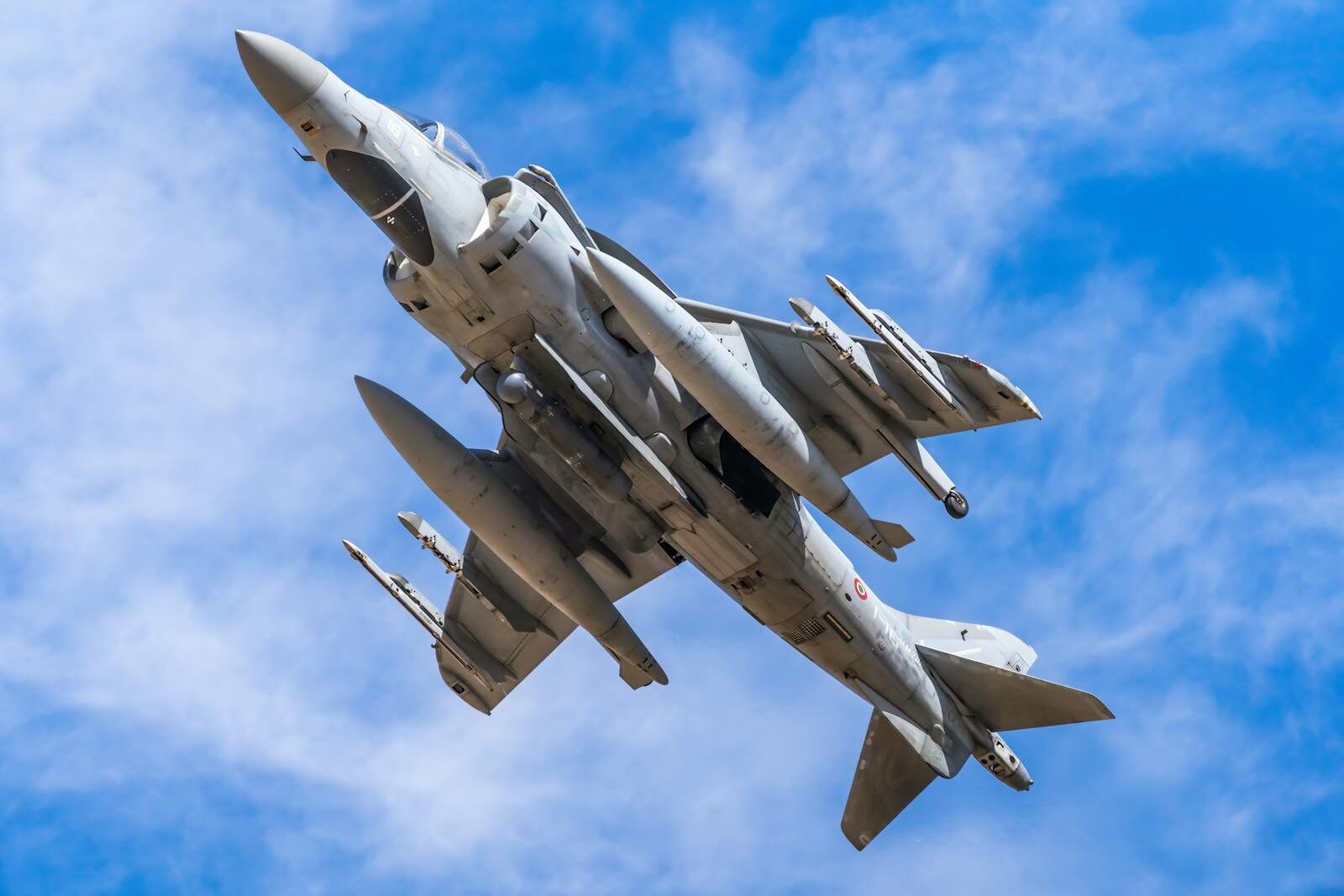 A military jet showcasing advanced technology soaring through a clear blue sky.