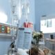 A patient receiving intravenous treatment in a hospital room, emphasizing healthcare and recovery.