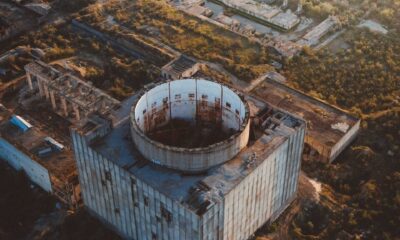 Drone shot of the abandoned Crimean nuclear power plant at sunset, showcasing decaying architecture.