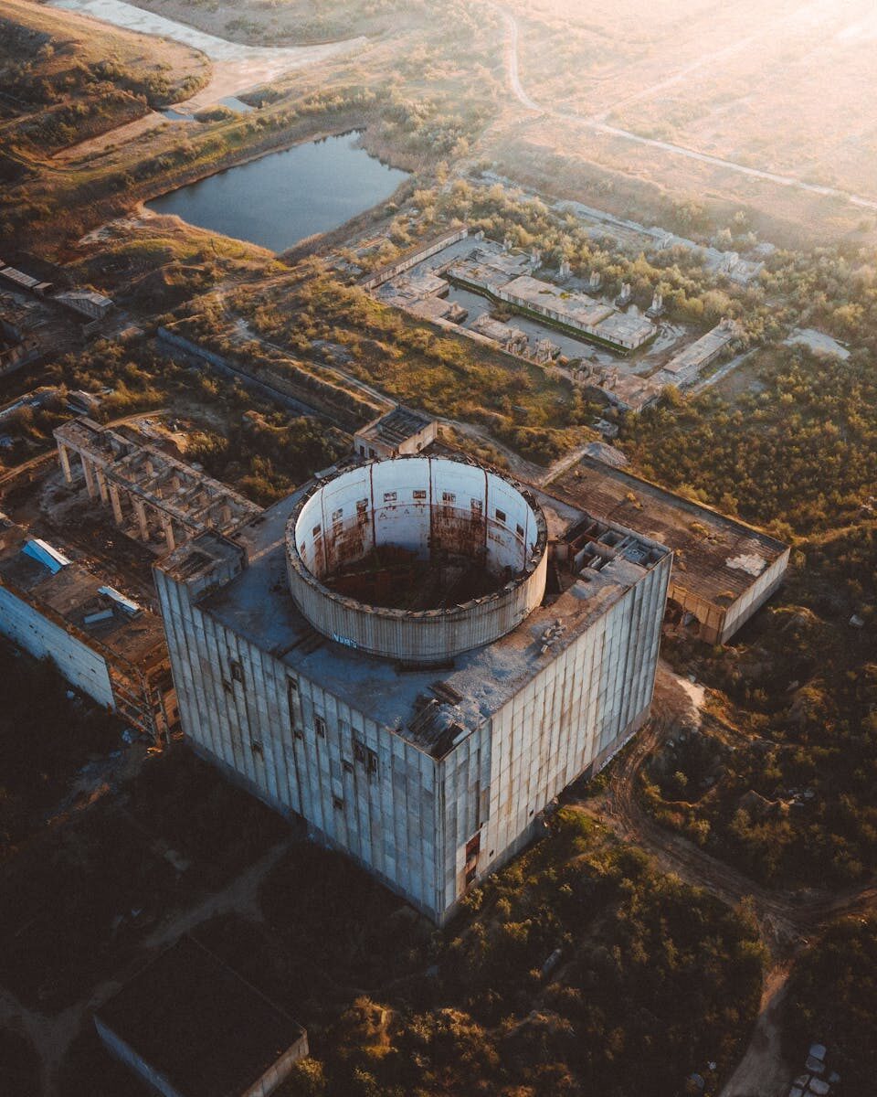 Drone shot of the abandoned Crimean nuclear power plant at sunset, showcasing decaying architecture.