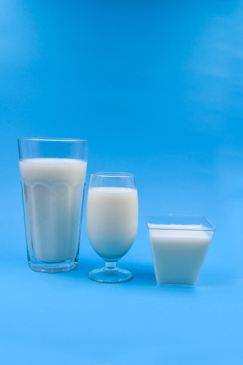 Three types of milk glasses on a blue backdrop, illustrating variety.