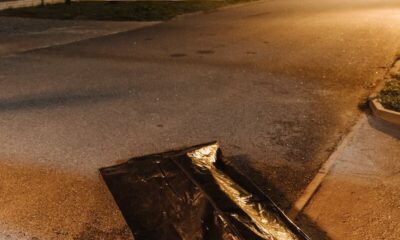 Crime scene at night with evidence bag and caution tape. Urban street setting.