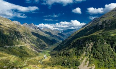 Explore the stunning Lauterbrunnen Valley showcasing lush greenery and majestic peaks under a vibrant blue sky.