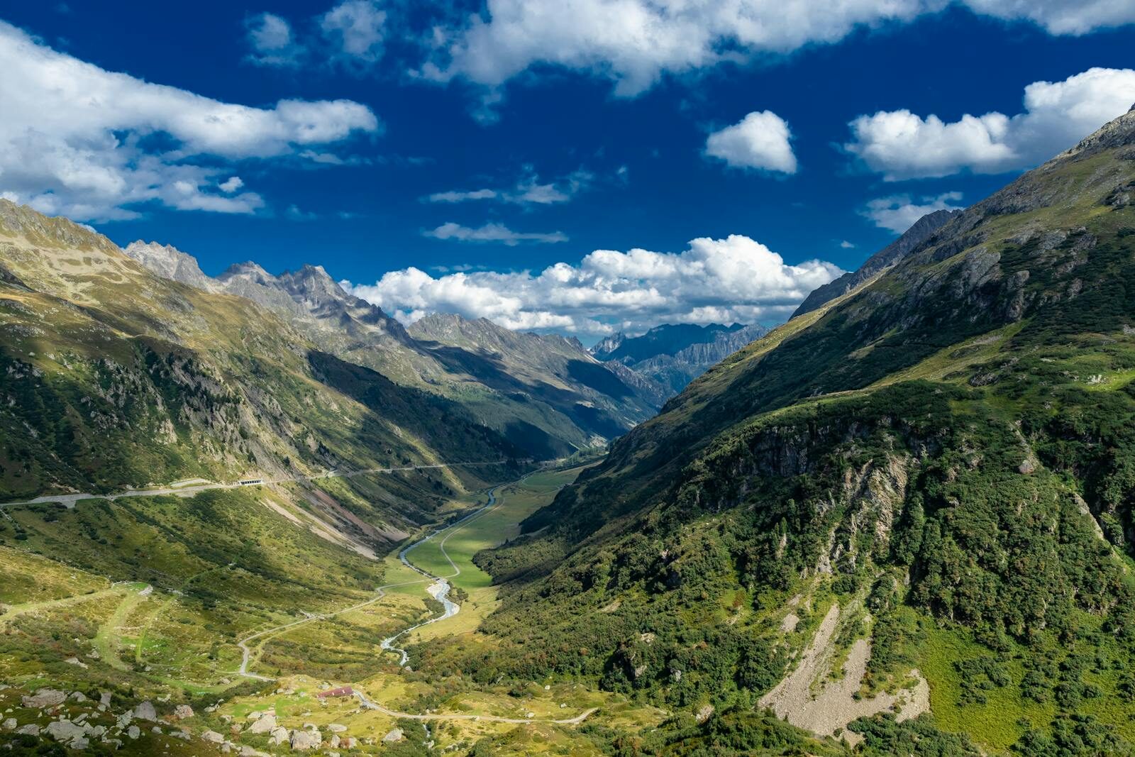 Explore the stunning Lauterbrunnen Valley showcasing lush greenery and majestic peaks under a vibrant blue sky.