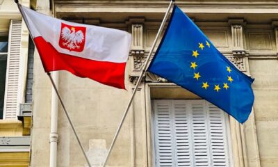 two flags are flying in front of a building