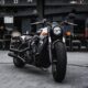 black and gray cruiser motorcycle parked beside black concrete building