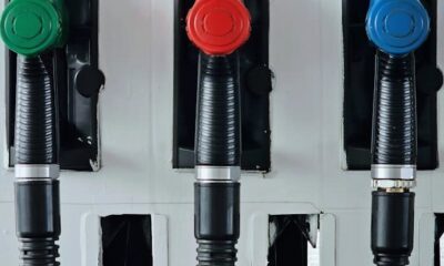 Close-up of vibrant green, red, and blue gas pump handles at a station.