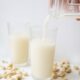 Delicious cashew milk being poured into a glass surrounded by cashews, showcasing refreshing plant-based nutrition.