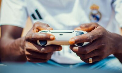 Focused gamer holds a controller, engrossed in a game, wearing team jersey.