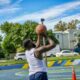 man in white tank top holding basketball