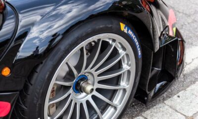 Modern black racing car highlighting sleek design and racing tire close-up for automotive enthusiasts.