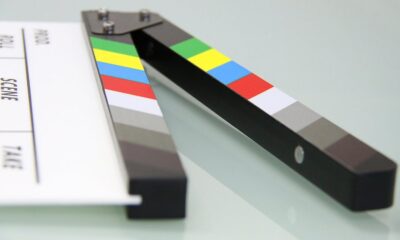 Colorful clapper board on a white surface, used in filmmaking. Ideal for entertainment and movie themes.