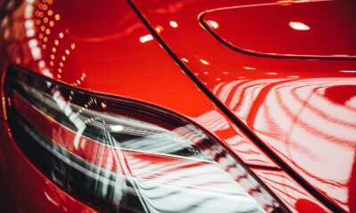 Detailed view of a shiny red car's tail light with bokeh reflections.