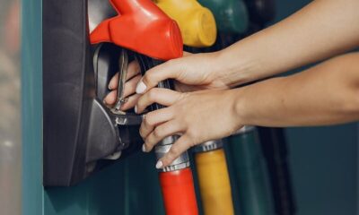 Unrecognizable female customer choosing fuel nozzle pump for filling car tank with gasoline on petrol station