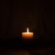 lighted candle in dark room