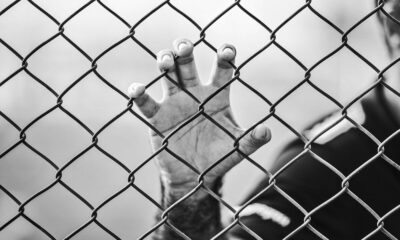 man holding chain-link fence