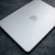 Closed silver laptop with apple logo on dark surface