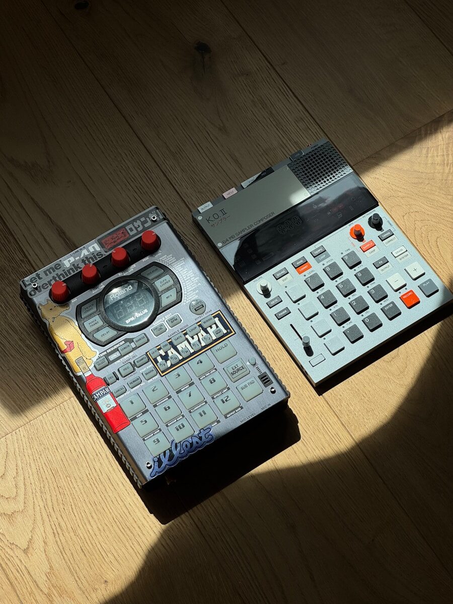 Two electronic music production devices on wooden floor.