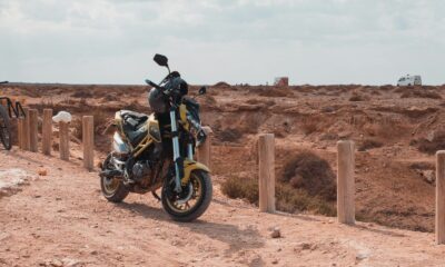a motorcycle parked on the side of a dirt road
