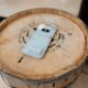 a cell phone sitting on top of a wooden barrel