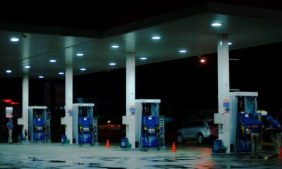 person taking a photo of blue and white gasoline station