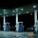 person taking a photo of blue and white gasoline station