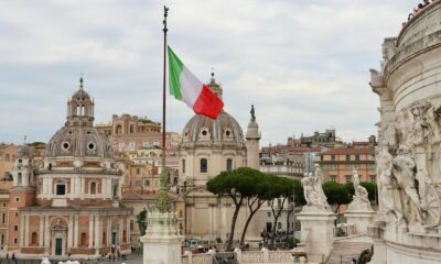 a flag flying in the air over a city