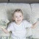 a little girl sitting on a couch holding money