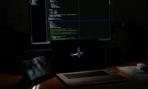 a laptop computer sitting on top of a wooden desk