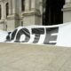 A large sign that says vote on it