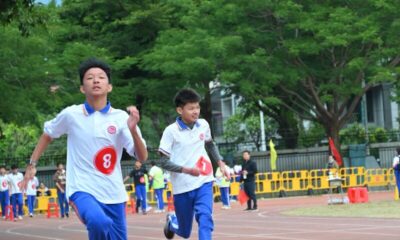 Two young boys race on a track.