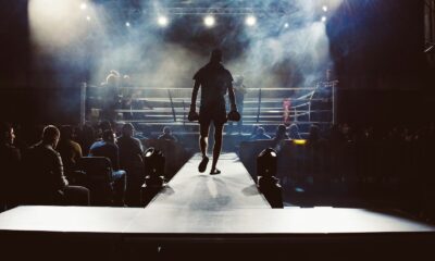 man standing and walking going on boxing ring surrounded with people