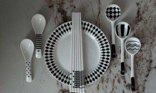 A table with a plate, spoons, and utensils on it