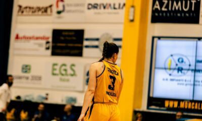 A man in a yellow uniform standing on a basketball court