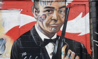 man in black suit jacket holding black rifle