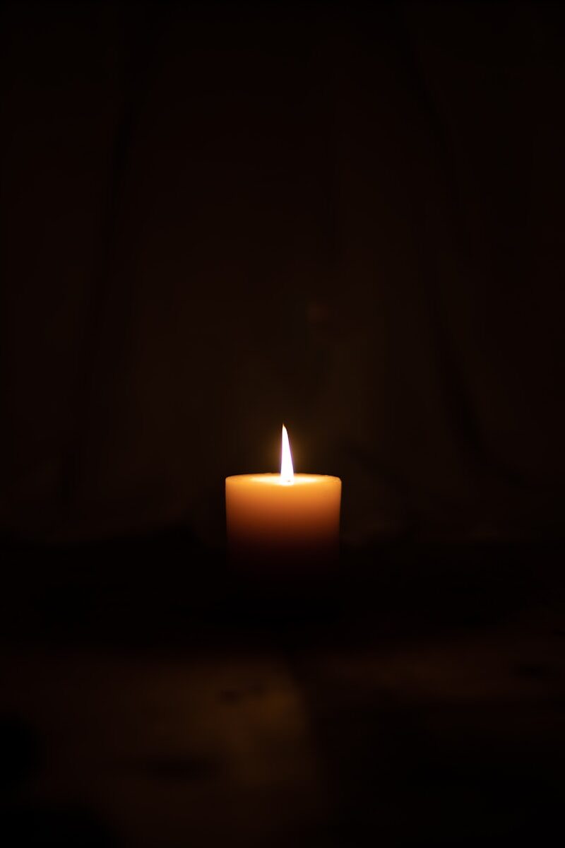 lighted candle in dark room