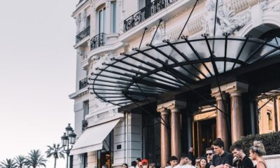 yellow sport car parked on street surrounded group of people