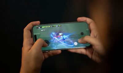 Hands holding a smartphone playing a video game.