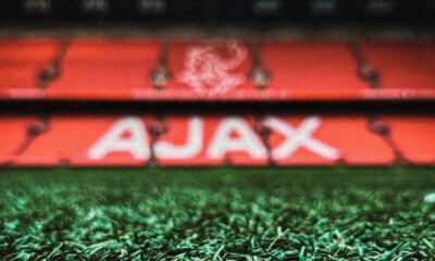 a soccer field with a stadium in the background