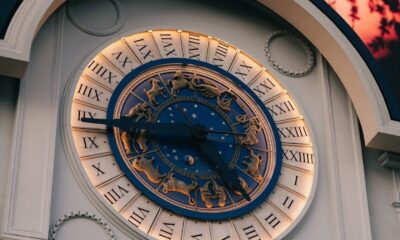 Ornate clock face with roman numerals and zodiac symbols