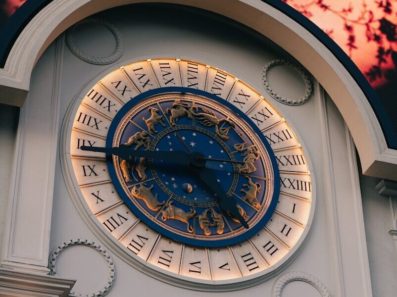 Ornate clock face with roman numerals and zodiac symbols