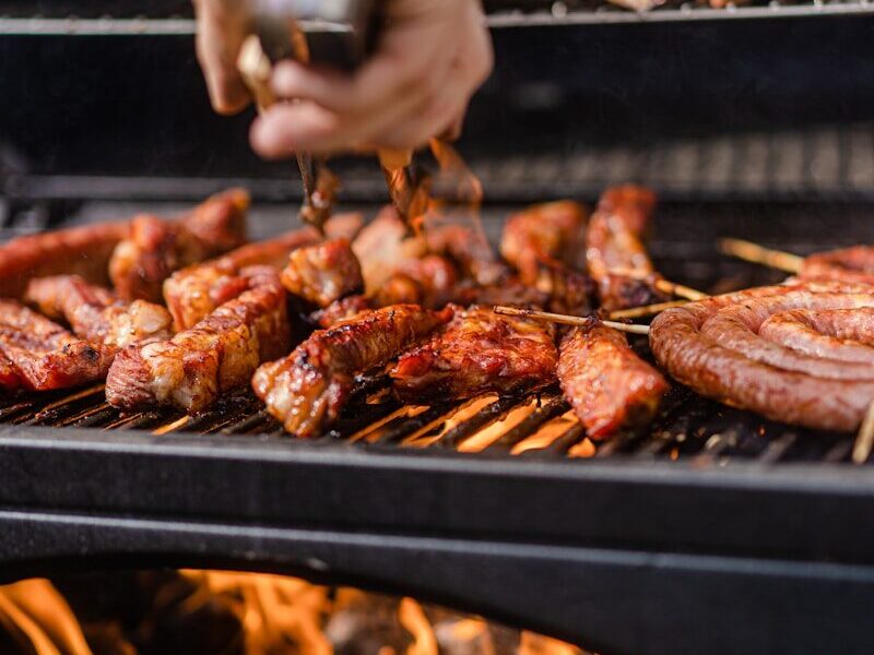 a person is cooking meat on a grill